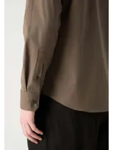 Camisa de vestir color marrón, corte slim, de popelín de algodón elástico, con cuello clásico, cierre frontal con botones y logo "ck" bordado en el pecho.