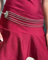 Cinturón de cadenas plateadas de múltiples capas con un dije central decorativo de estilo étnico con diseño grabado.