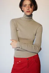 Jersey de punto con lana, color celeste, de cuello subido y manga larga, con diseño ajustado al cuerpo.