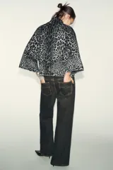 Jersey de punto con estampado animal jacquard en tonos gris y negro, caracterizado por su cuello subido y mangas anchas de corte holgado.