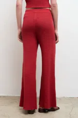 Pantalón largo color crema, de punto acanalado y corte recto.