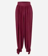 Pantalón de corte aladino con volumen en las piernas, confeccionado en tejido piquet. Presenta cintura elástica y detalle de lazos para anudar en los tobillos.