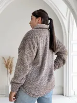 Campera de abrigo color marrón con textura de peluche, cierre frontal con cremallera y bolsillo de parche en el pecho.