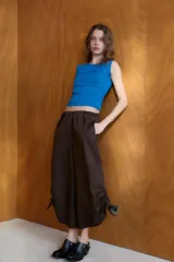 Pantalón culotte de tiro medio con cintura elástica, bolsillos laterales ocultos y bajo con abertura ajustable mediante cordones laterales.