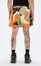 Short de baño de microfibra de secado rápido, con estampado abstracto en tonos naranja, verde, blanco y marrón. Incluye malla interna y un bolsillo trasero con ojalillo.