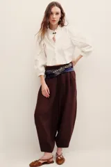 Pantalón babucha negro de lino, de corte holgado estilo barrel con pinzas en la cintura y bolsillos laterales.