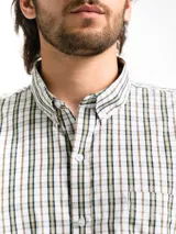 Camisa de hombre de manga corta con estampado a cuadros en tonos blanco, verde y marrón. Tiene cuello abotonado y bolsillo en el pecho.