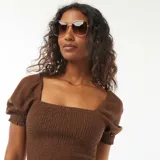 Blusa crop marrón con escote cuadrado, mangas cortas abullonadas y cuerpo smock.