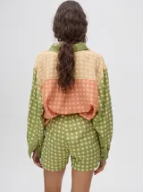 Short de corte boxy confeccionado en viscosa con estampado geométrico de estrellas en tonos rosados. Presenta una pretina elástica en color naranja y cordón de ajuste en color marrón.