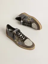 Championes Golden Goose modelo Ball Star, confeccionados en cuero color gris, marrón y beige, con estrella dorada en el lateral, detalles en rojo en el talón y suela de goma color caramelo.