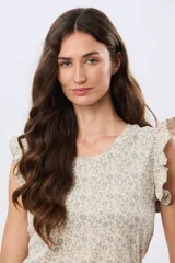 Musculosa blanca con estampado floreado sutil y volados en los hombros, de corte recto.