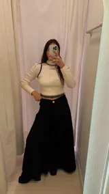 Pantalón palazzo negro de tiro alto con pinzas delanteras y bolsillos laterales.