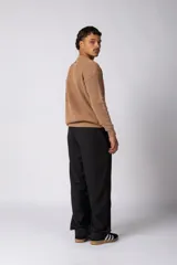 Sweater de punto grueso con textura waffle, de calce relajado y cuello redondo. Presenta puños y ruedo acanalados, con un pequeño parche con logo en el puño izquierdo.