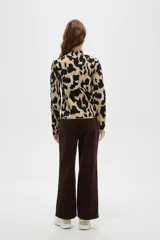 Polera de tejido jacquard con diseño abstracto, cuello alto y mangas largas, de corte ajustado al cuerpo.