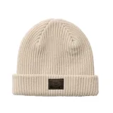 Gorro tipo beanie de punto acanalado en color beige, con vuelta en el borde y parche de cuero oscuro con logo de la marca en el frente.