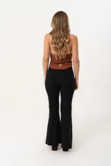 Pantalón negro de tiro alto con cierre frontal de cremallera y botón, bolsillos delanteros y traseros, y corte evasé en el bajo.