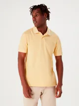 Chomba de manga corta con cuello polo y cierre frontal de botones, confeccionada en tejido de punto liso.