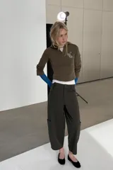 Pantalón cargo de tiro alto con corte holgado y diseño de volumen. Presenta bolsillos laterales tipo cargo, bolsillos frontales clásicos y cierre frontal con cremallera y botón.