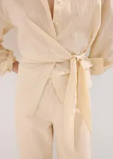 Jeans de corte recto y tiro medio en color beige claro, con diseño clásico de cinco bolsillos y presillas para cinto.