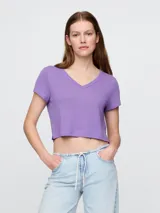 Remera crop de lino color violeta, con cuello en V y mangas cortas.
