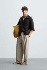 Camisa de corte relajado confeccionada en tejido mezcla de lyocell, con cuello solapa, manga corta y cierre frontal con botonadura oculta.