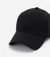 Gorra negra de sarga de algodón, con visera curva y bordado frontal con las letras "NY". Ajuste trasero con hebilla metálica.