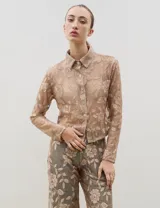 Camisa de encaje con diseño floral, de corte recto y manga larga, con cierre frontal de botones clásicos y cuello camisero.