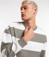 Buzo de algodón y poliéster con cuello redondo y mangas largas. Diseño a rayas horizontales en color blanco y gris. Puños y bajo acanalados.