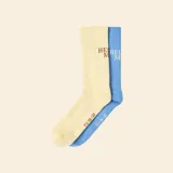 Pack de dos pares de medias deportivas de caña alta, una en color amarillo pastel y otra en color azul, con detalle de logo bordado y textura acanalada en el empeine.