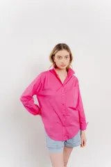 Camisa fucsia de algodón, corte clásico, manga larga y cierre con botones.