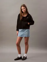 Buzo negro con capucha y cierre frontal completo, confeccionado en suave fleece de mezcla de algodón y poliéster. Presenta el logo Archive de Calvin Klein bordado en el pecho, bolsillos laterales y un corte regular.