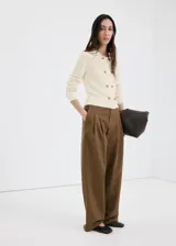 Chaqueta de punto de algodón color marfil, con diseño recto, cuello camisero, manga larga y cierre de doble botonadura con botones carey.