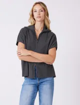 Cardigan gris jaspeado de punto de galga media, con cierre frontal metálico completo y cuello con solapa. Presenta mangas cortas de sisa caída y un corte recto y holgado que llega a la altura de la cadera.