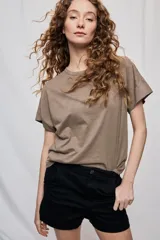Remera negra de manga corta con cuello redondo y silueta amplia, de hombros caídos y textura suave.