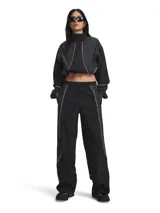 Pantalón deportivo negro de corte holgado, confeccionado en tejido ripstop ultrarresistente con acabado brillante. Cuenta con cintura elástica, bolsillos laterales con cierre y detalles de ribetes blancos en los laterales.