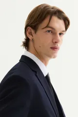 Blazer de hombre color azul marino oscuro, de corte slim fit, con solapas de muesca finas, botonadura sencilla de un botón visible, bolsillo superior insertado y dos bolsillos delanteros con solapa.