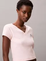 Remera de Calvin Klein confeccionada en algodón elástico con textura de canalé fino. Presenta un diseño de corte slim, cuello en V, manga corta y una insignia con el logo de la marca en el pecho.