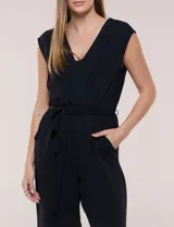 Enterito Luxology de crepÃ© color verde, sin mangas, con escote cruzado en V, cintura elastizada con lazo de ajuste y pantalÃ³n de corte amplio.