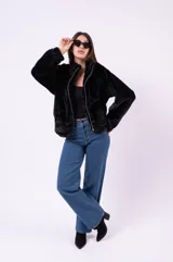 Campera de piel sintética con estampado animal print de leopardo, corte holgado, cuello alto y cierre frontal completo.