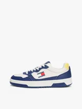 Zapatillas Tommy Jeans de corte bajo, confeccionadas en piel color blanco y azul con detalles en amarillo. Presentan suela cupsole, detalle de ventilación en la parte superior, logo de Tommy Jeans en relieve en la entresuela y parche de Tommy en el lateral.