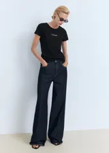 Camiseta de punto color negro, de corte recto, con cuello redondo, mangas cortas y estampado frontal con el texto "MANGO".