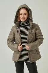 Campera puffer con capucha, color camel, confeccionada en poliéster con relleno acolchado, cierre frontal y diseño entallado.