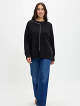 Buzo de punto color negro con cuello redondo, mangas largas y detalle de costura vertical en color blanco que recorre el frente. Presenta terminaciones acanaladas en puños y cintura, con un corte relajado.