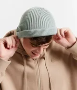 Gorro tipo fisherman de tejido acrílico con textura acanalada y diseño corto, ideal para climas fríos.