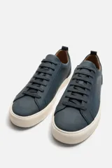 Zapatilla de cordones color beige, con parte superior lisa, horma redonda, forro interior a contraste y suela con ligera textura.