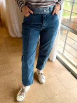 Jean mom fit de tiro alto color azul, con costuras frontales en contraste y pretina ancha con botones decorativos. Confeccionado en denim de algodón con elasticidad.
