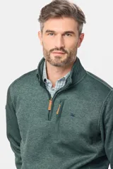 Buzo de felpa con interior polar, diseño de medio cierre frontal, cuello alto y bolsillo vertical en el pecho con cierre. Presenta un acabado jaspeado y logo bordado en el frente.