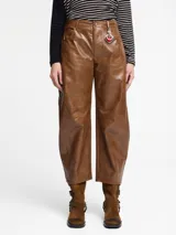 Pantalón de silueta globo confeccionado en cuero sintético con acabado efecto vintage, de tiro medio y pierna ancha con costuras horizontales en las rodillas.