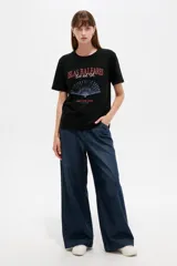 Remera de algodón manga corta color negro, con cuello redondo y estampado frontal con motivos en tonos rojos y azules.