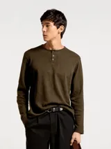 Camiseta de manga larga estilo Henley, confeccionada en tejido de algodón con textura, cuello redondo con tapeta de botones y corte clásico.